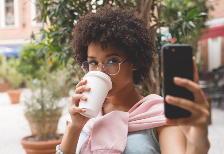 personne faisant un selfie en buvant son café